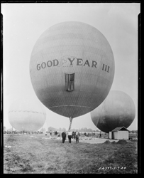 A4337_24 “Goodyear III Balloon” The Goodyear III balloon in a field with three men posing in front.  1924-05-07